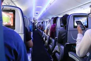 Airplane aisle with passengers on seats